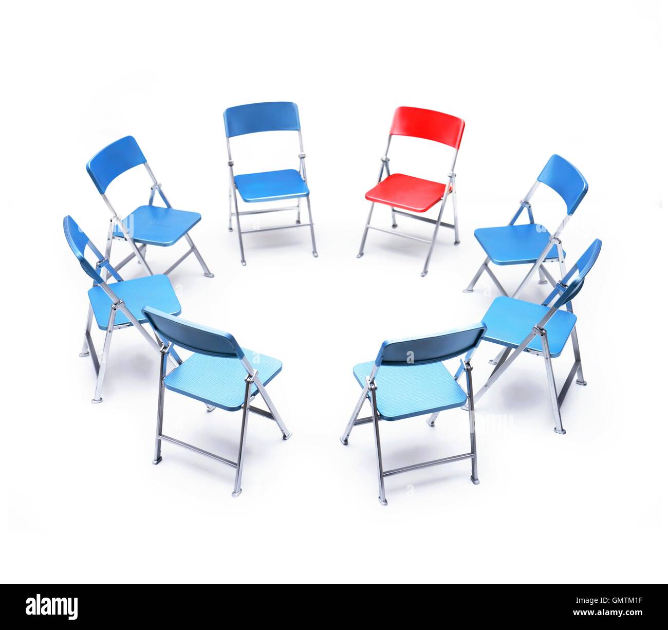 Cercle de chaises bleues avec un fauteuil rouge. Banque D'Images