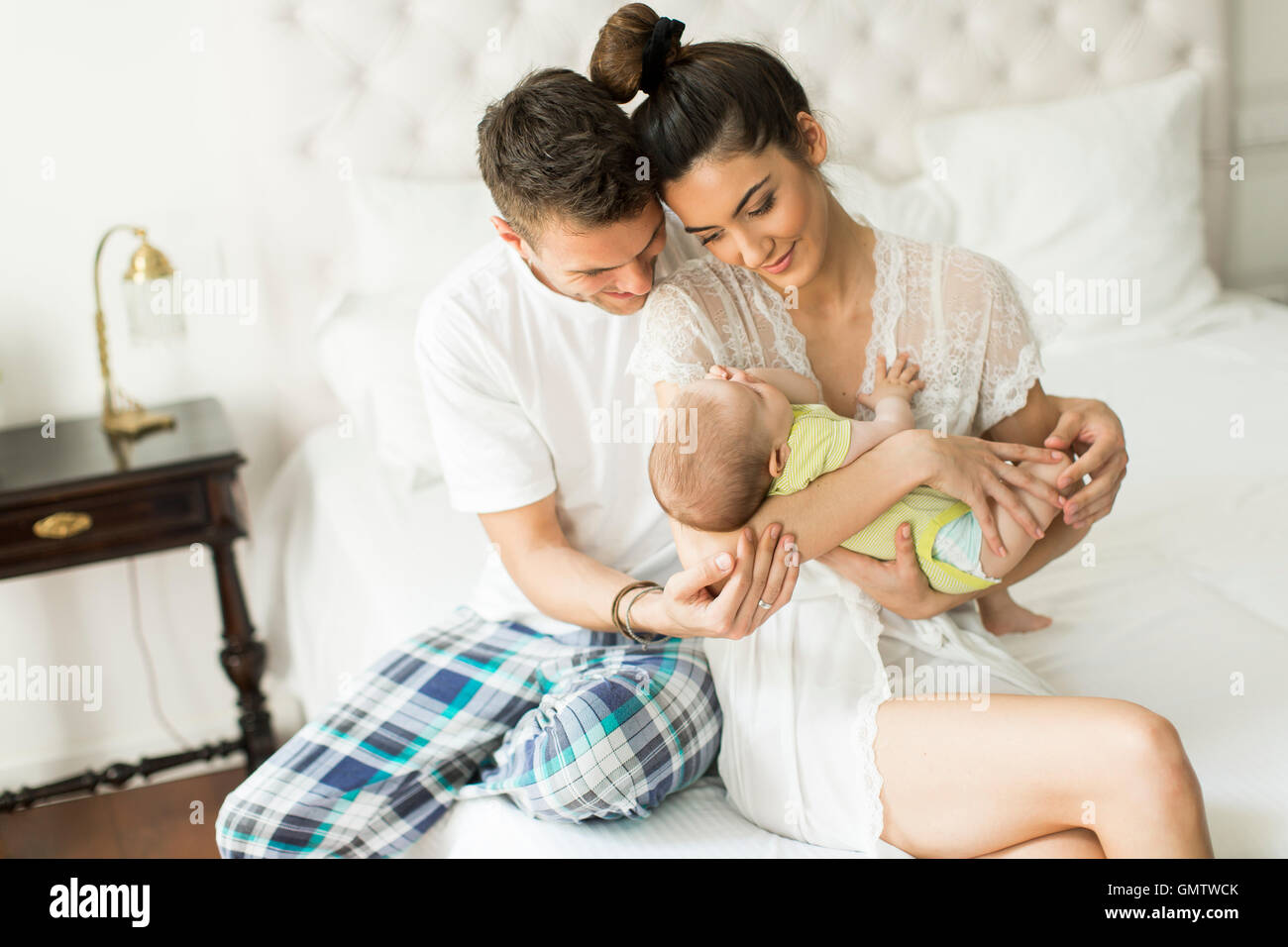 Jeune couple sur le lit avec bébé fille Banque D'Images