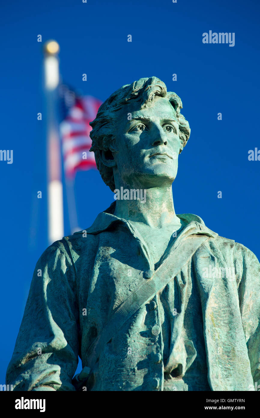 Le Capitaine Parker statue sur Battle Green avec le drapeau américain, Lexington Green, Lexington, Massachusetts Banque D'Images