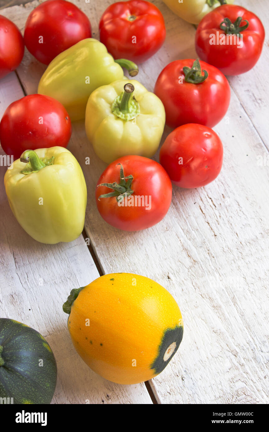 Les tomates, le poivron et les courgettes sur la surface en bois blanc Banque D'Images