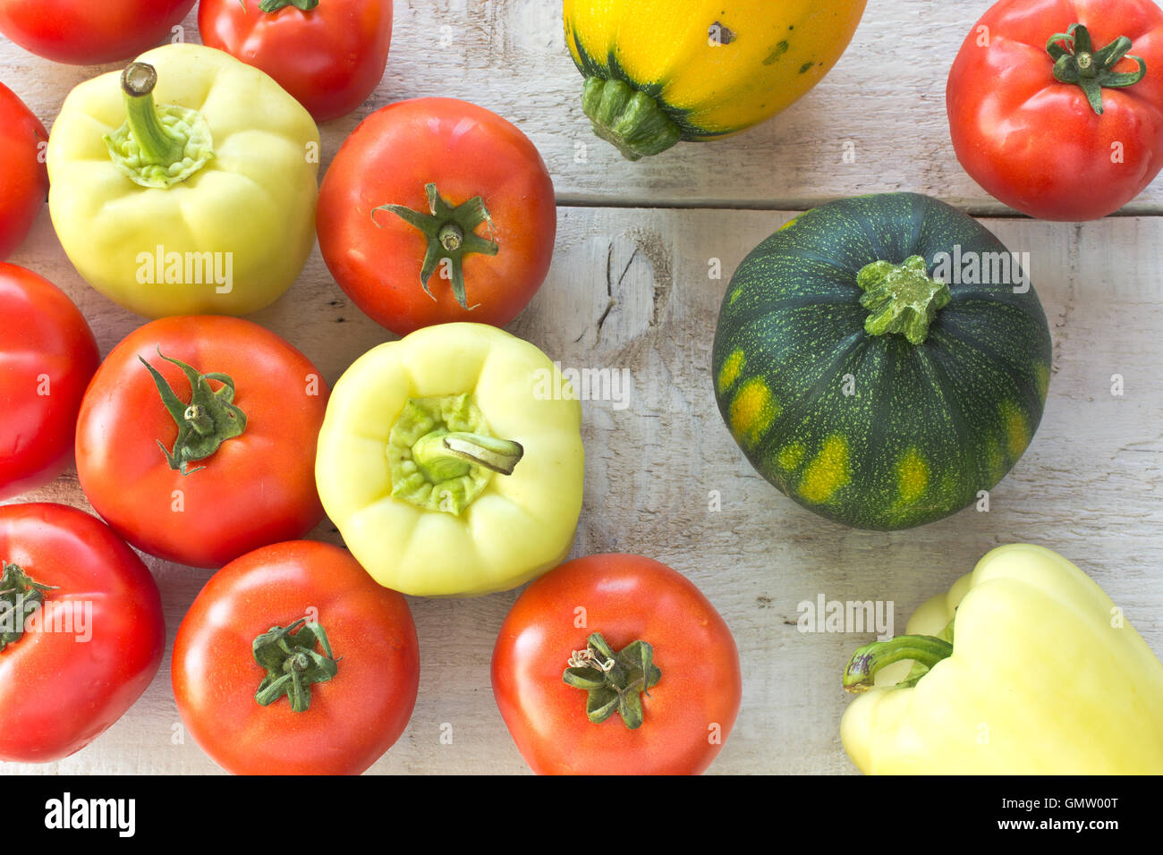 Les tomates, le poivron et les courgettes sur la surface en bois blanc Banque D'Images