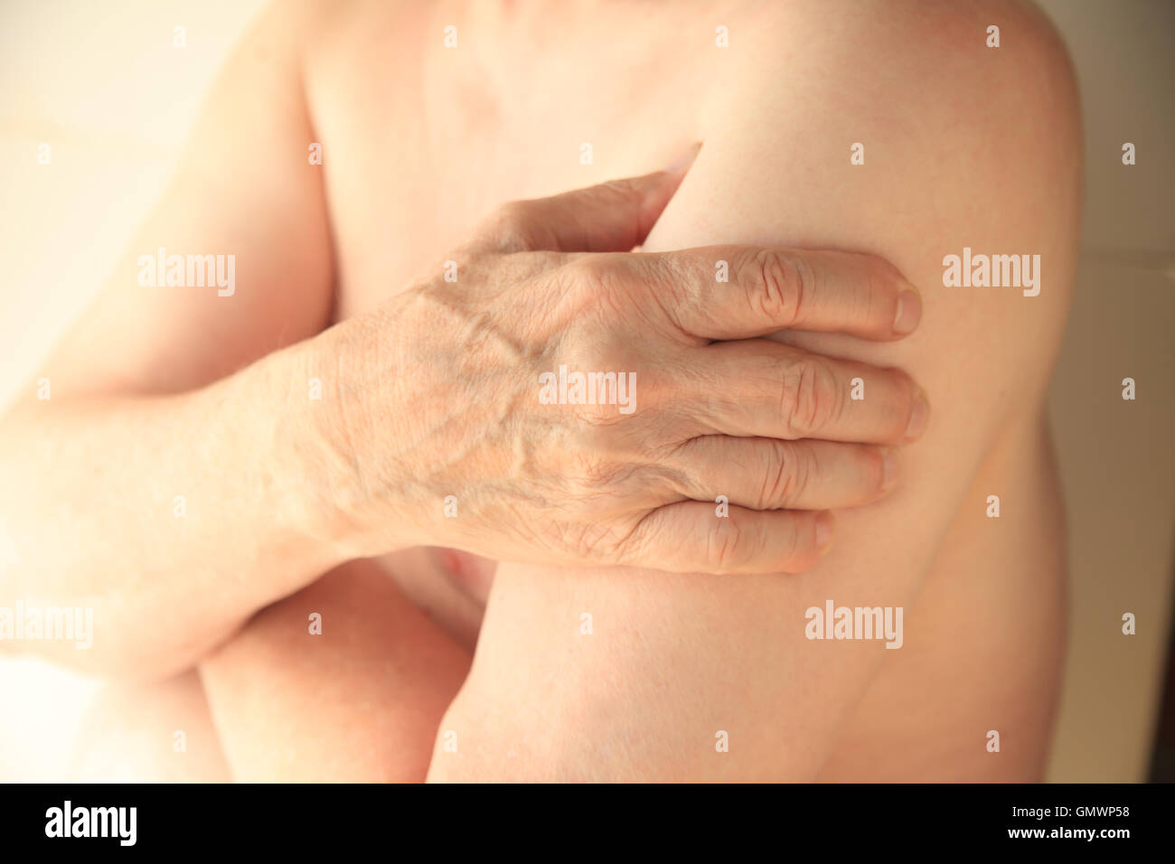 Un homme plus âgé avec sa main sur un muscle du bras endoloris. Banque D'Images