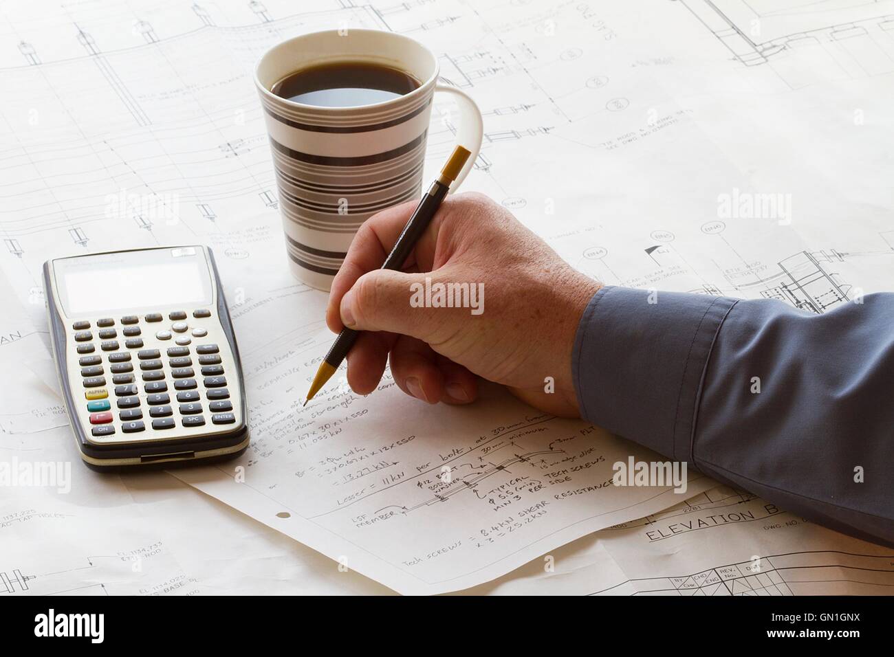 Faire des calculs à la main sur l'ingénieur une feuille de calcul, avec une  calculatrice et tasse de café Photo Stock - Alamy