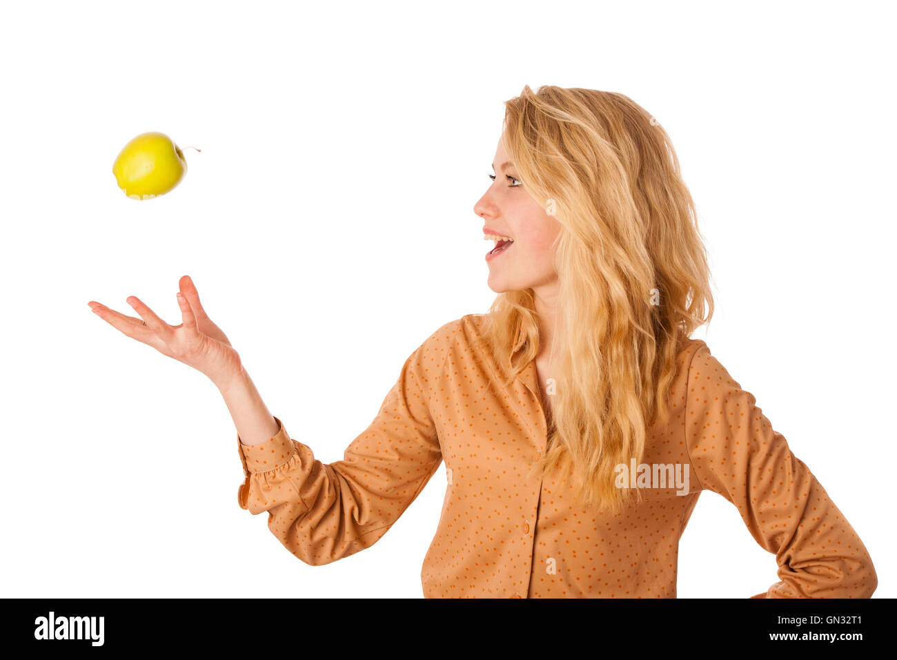 Très belle jeune femme blonde caucasienne mange une pomme verte comme un signe de saine alimentation isolated over white Banque D'Images