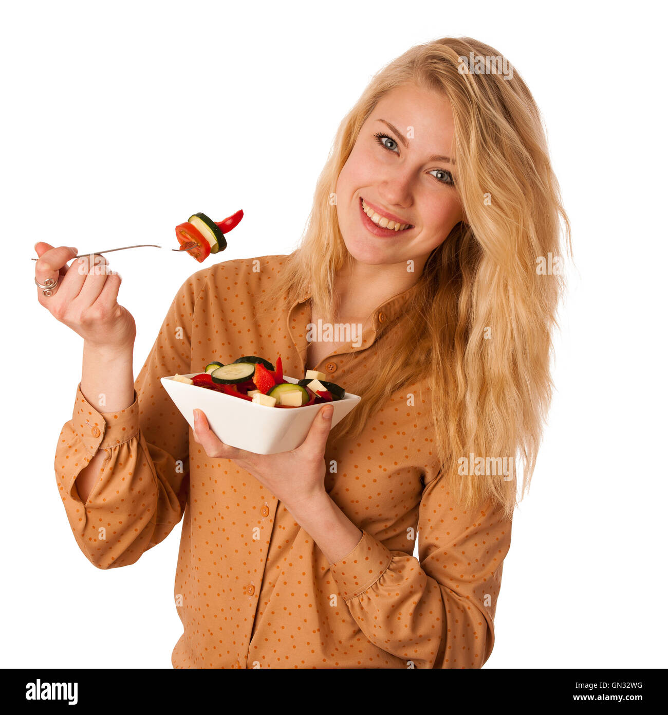 Très belle jeune femme blonde caucasienne mange une délicieuse salade comme un signe de saine alimentation isolated over white Banque D'Images