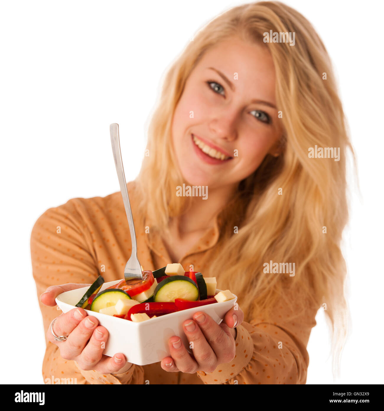 Très belle jeune femme blonde caucasienne mange une délicieuse salade comme un signe de saine alimentation isolated over white Banque D'Images