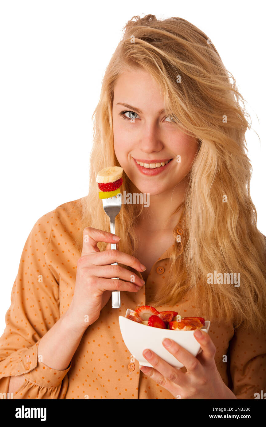 Très belle jeune femme blonde caucasienne est titulaire d'une délicieuse salade de fruits comme un signe de saine alimentation isolé sur fond blanc Banque D'Images