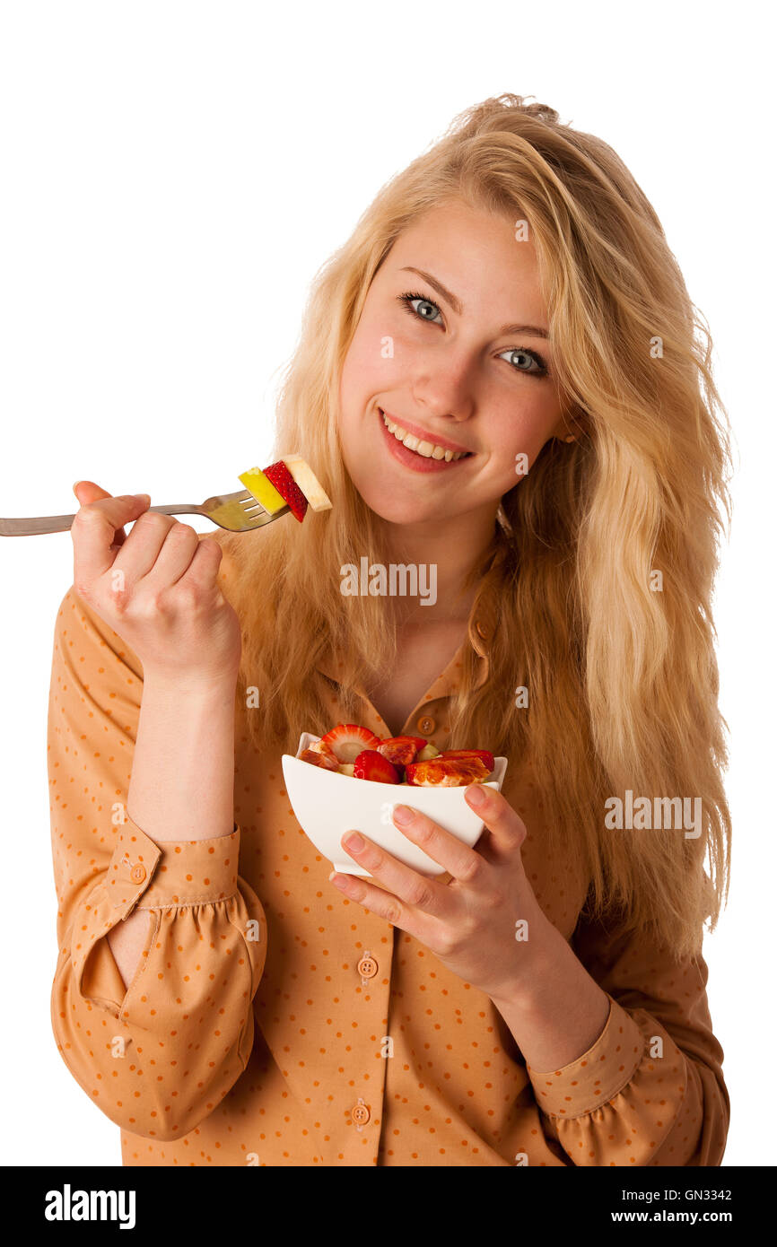 Très belle jeune femme blonde caucasienne est titulaire d'une délicieuse salade de fruits comme un signe de saine alimentation isolé sur fond blanc Banque D'Images
