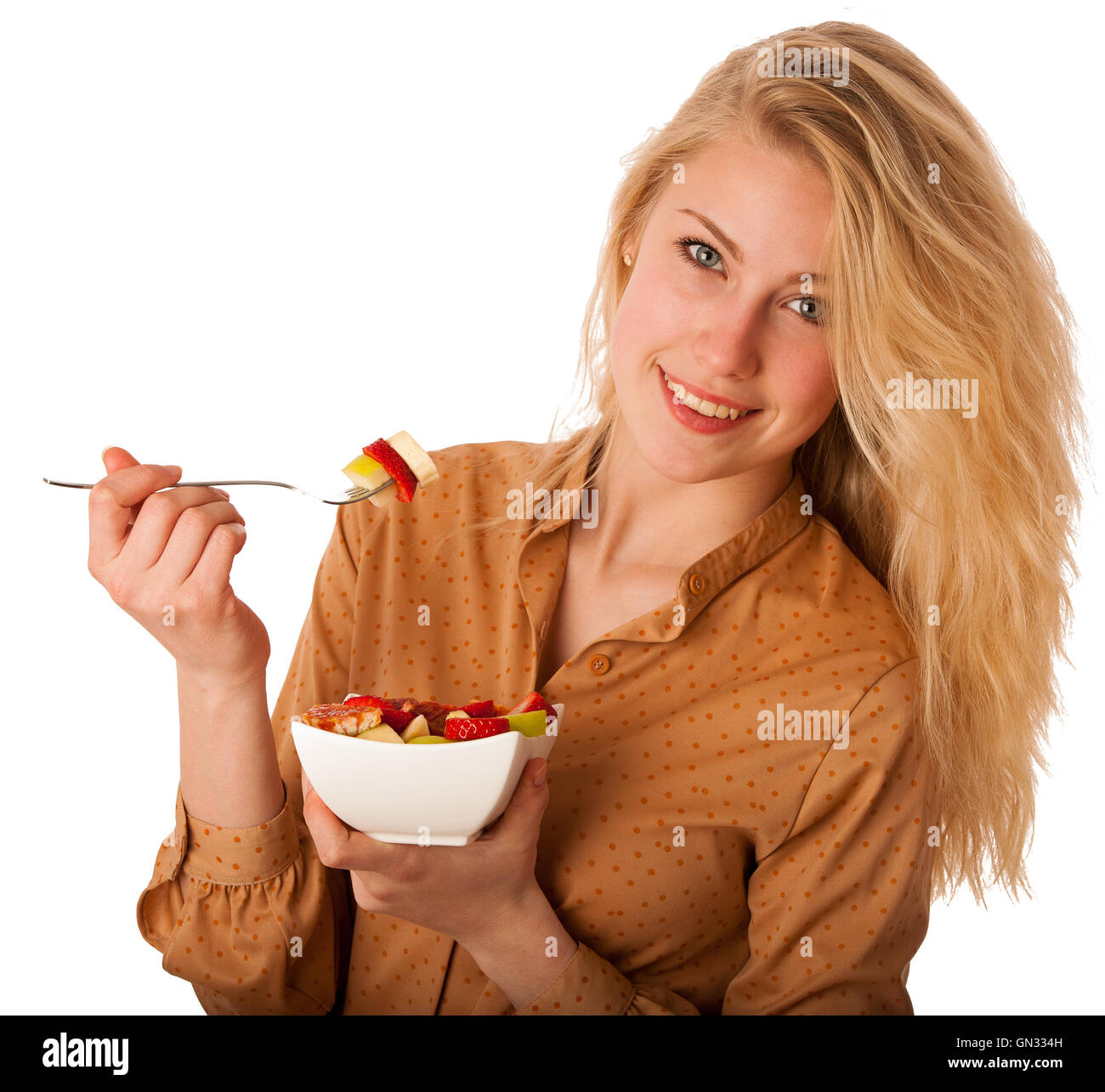 Très belle jeune femme blonde caucasienne est titulaire d'une délicieuse salade de fruits comme un signe de saine alimentation isolé sur fond blanc Banque D'Images