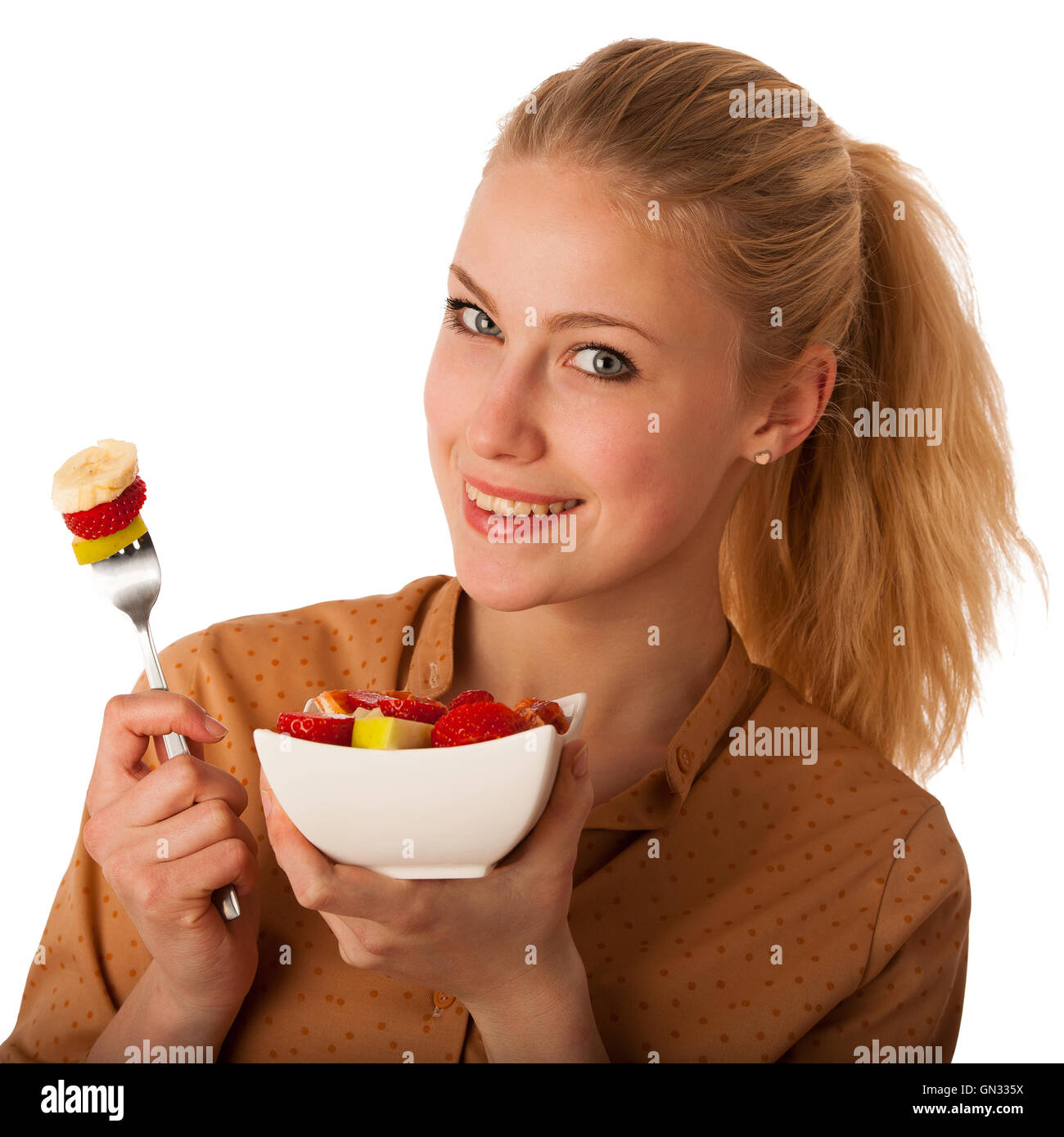 Très belle jeune femme blonde caucasienne est titulaire d'une délicieuse salade de fruits comme un signe de saine alimentation isolé sur fond blanc Banque D'Images