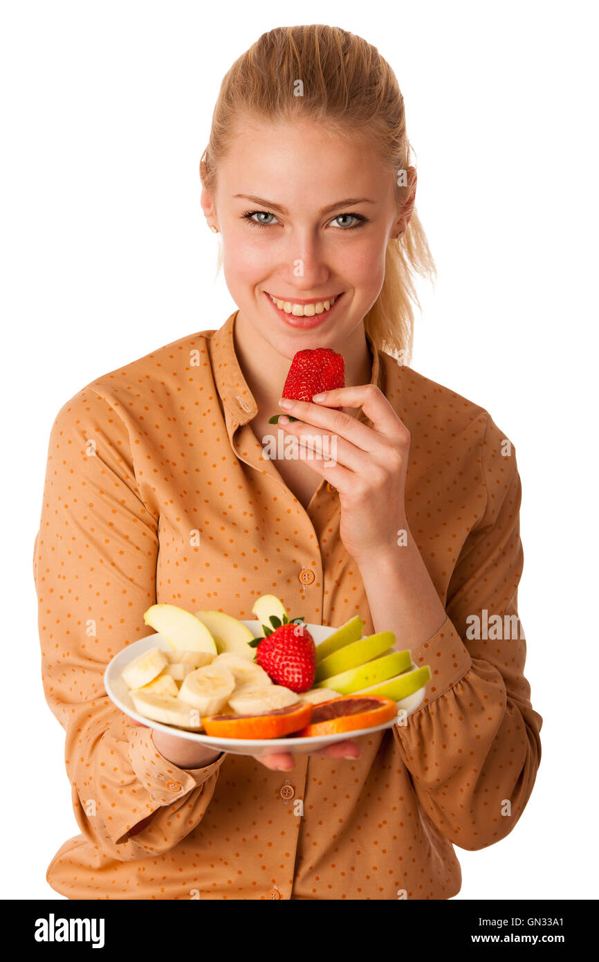 Très belle jeune femme blonde caucasienne est titulaire d'une délicieuse salade de fruits comme un signe de saine alimentation isolé sur fond blanc Banque D'Images