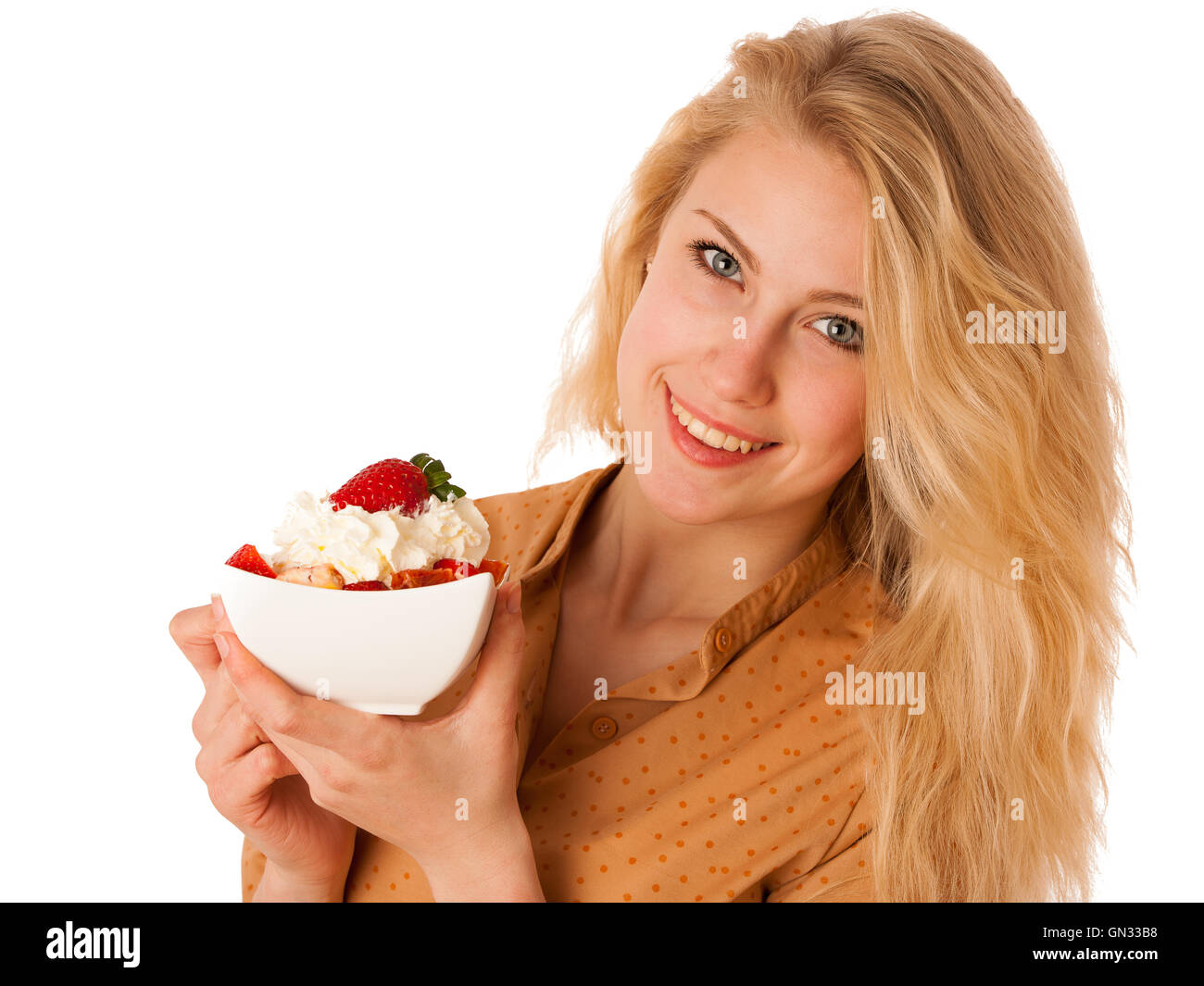 Très belle jeune femme blonde caucasienne est titulaire d'une délicieuse salade de fruits comme un signe de saine alimentation isolé sur fond blanc Banque D'Images