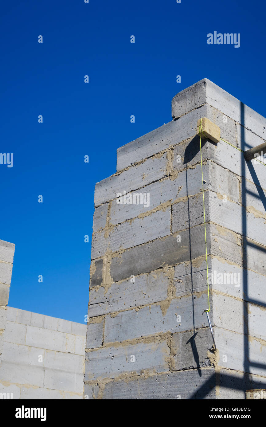 Builder's à plomb accroché contre coin extérieur mur de chambre Création en cours. Banque D'Images