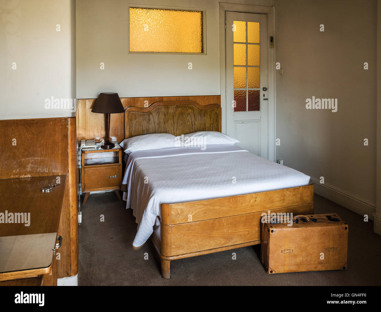 Chambre d'hôtel vintage style européen avec des bagages à l'avant du lit. Banque D'Images