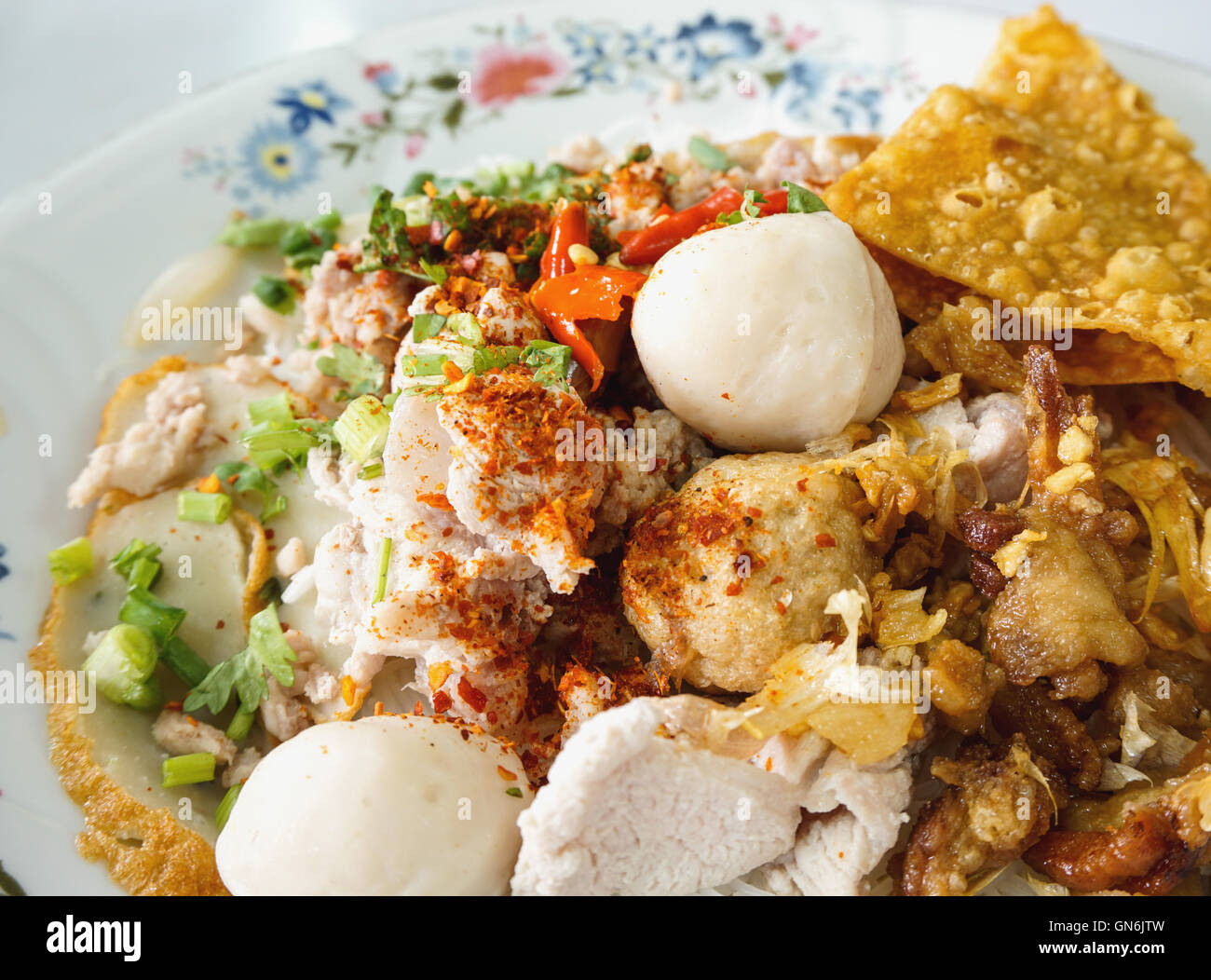 Épicé nouilles sèches avec le porc, le poisson ballon, et fried wonton, selective focus Banque D'Images