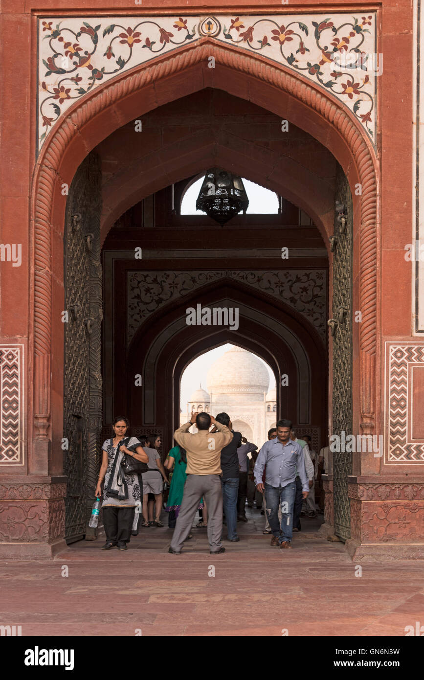 Les visiteurs de marcher sous la grande arche de la grande porte (Darwaza-i rauza) le Taj Mahal à Agra, Uttar Pradesh, Inde Banque D'Images