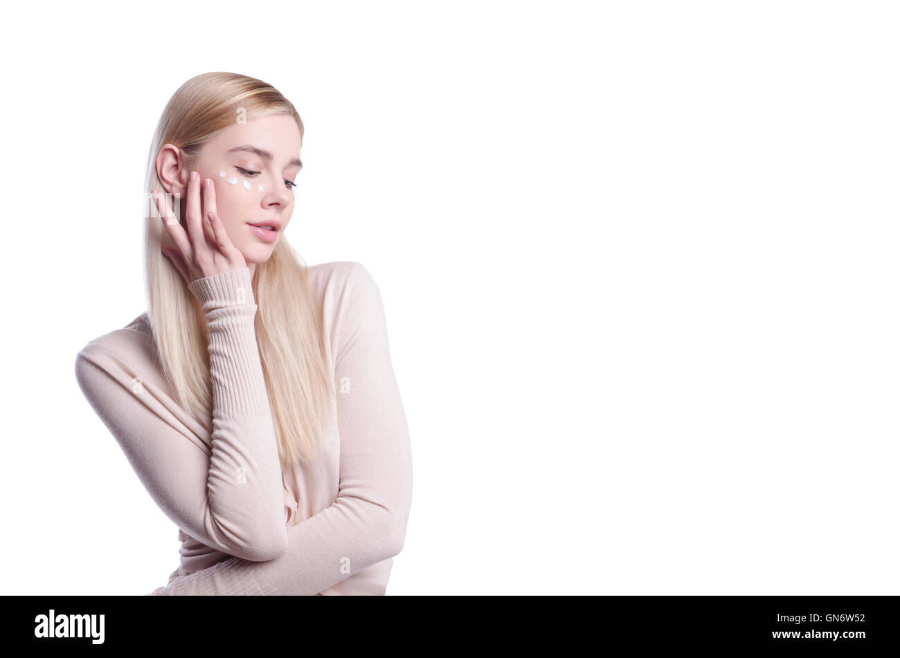 Belle Jeune femme appliquez la crème pour le visage et dans les yeux, effet rajeunissant, lisse les rides, réduit les pores et la peau dure, beau visage color Banque D'Images