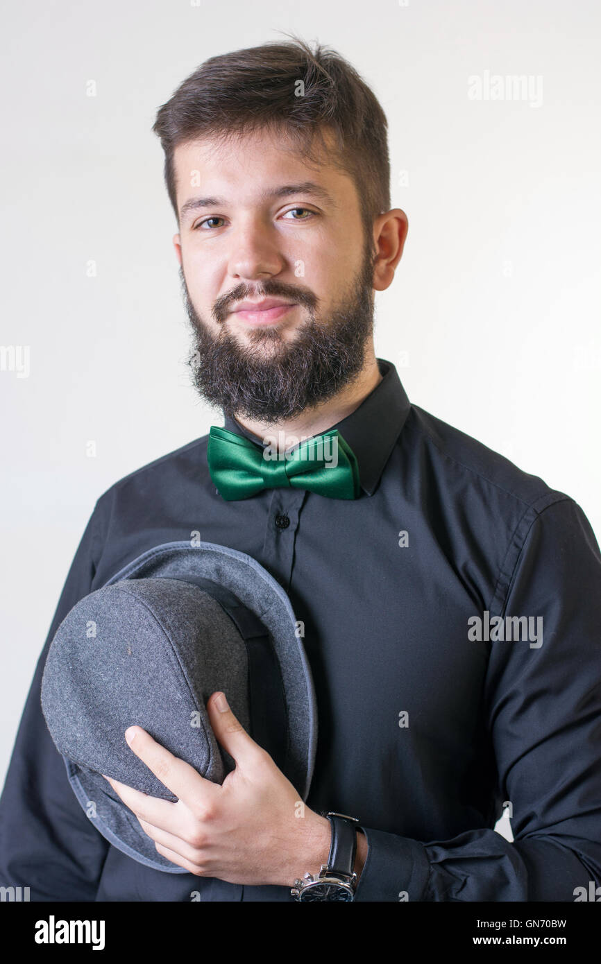 Homme élégant dans une chemise noire avec une cravate d'arc Banque D'Images