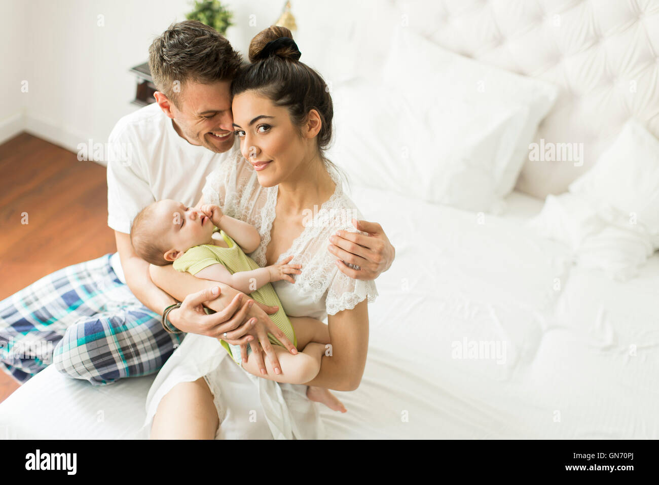Famille heureuse avec bébé nouveau-né sur le lit dans la chambre Banque D'Images