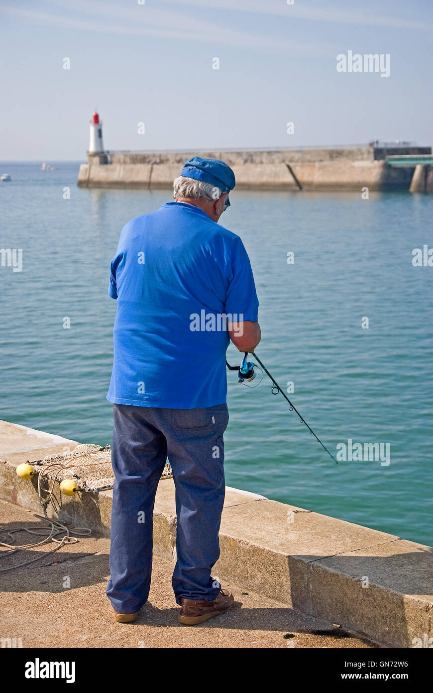 Vieil homme en chemise bleue du quai de pêche à Les Sables d'Olonne en Vendée Banque D'Images