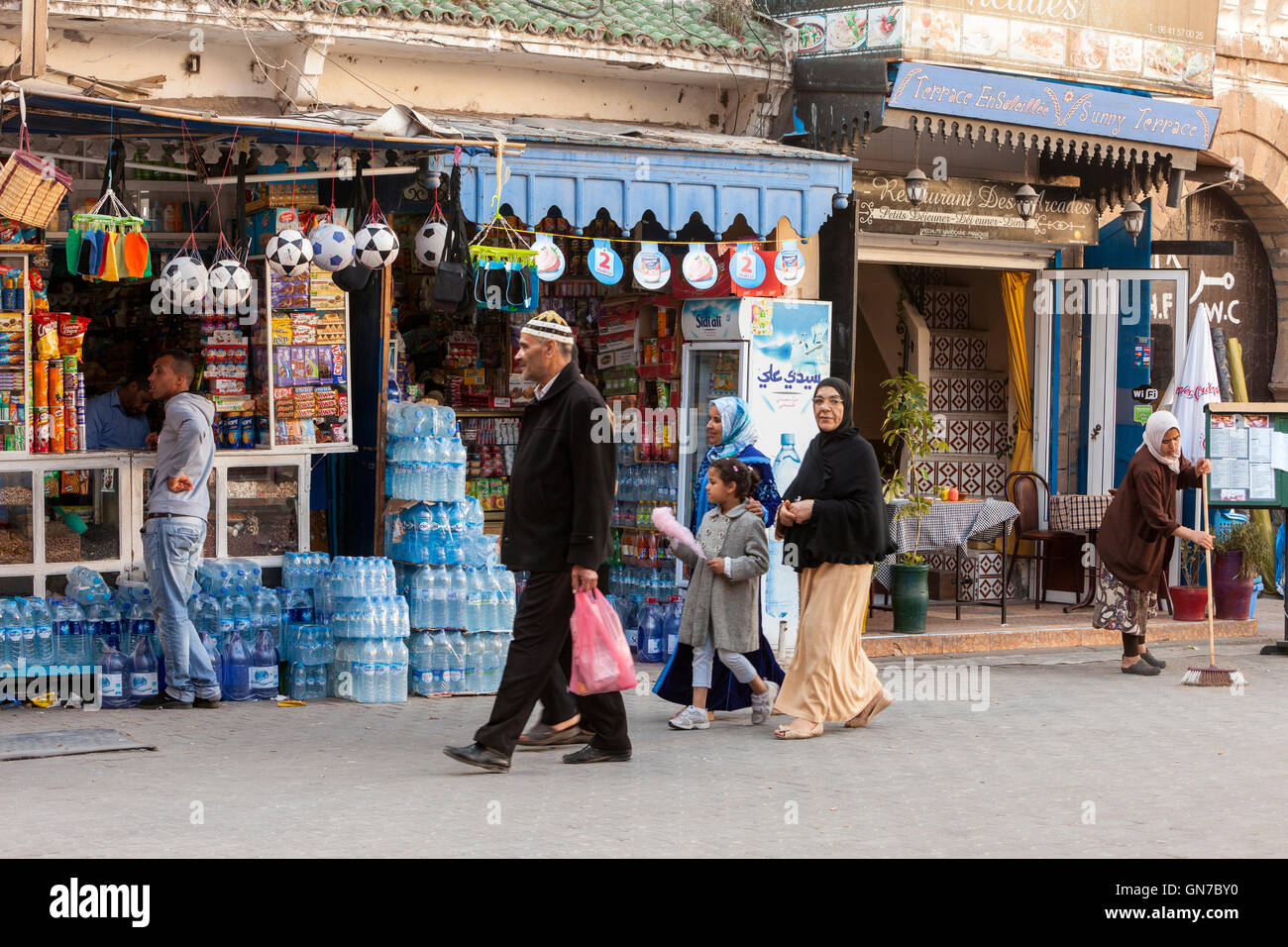 Essaouira, Maroc. Balades en famille, Avenue de l'Istiqlal. L'eau embouteillée et des ballons de football pour la vente. Banque D'Images