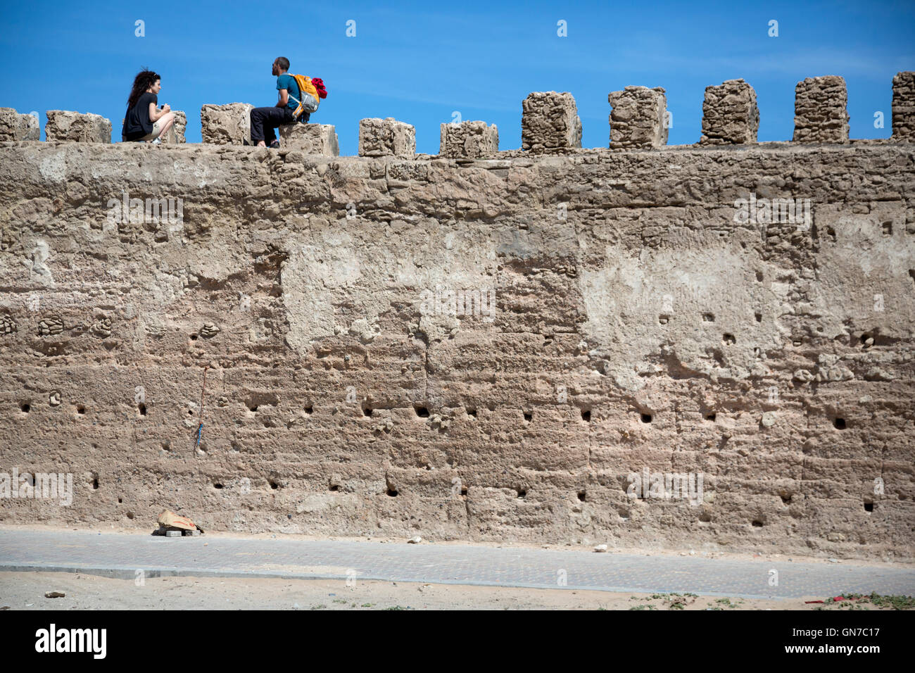 Essaouira, Maroc. Les touristes reste au sommet de remparts de la ville face à la mer. Banque D'Images