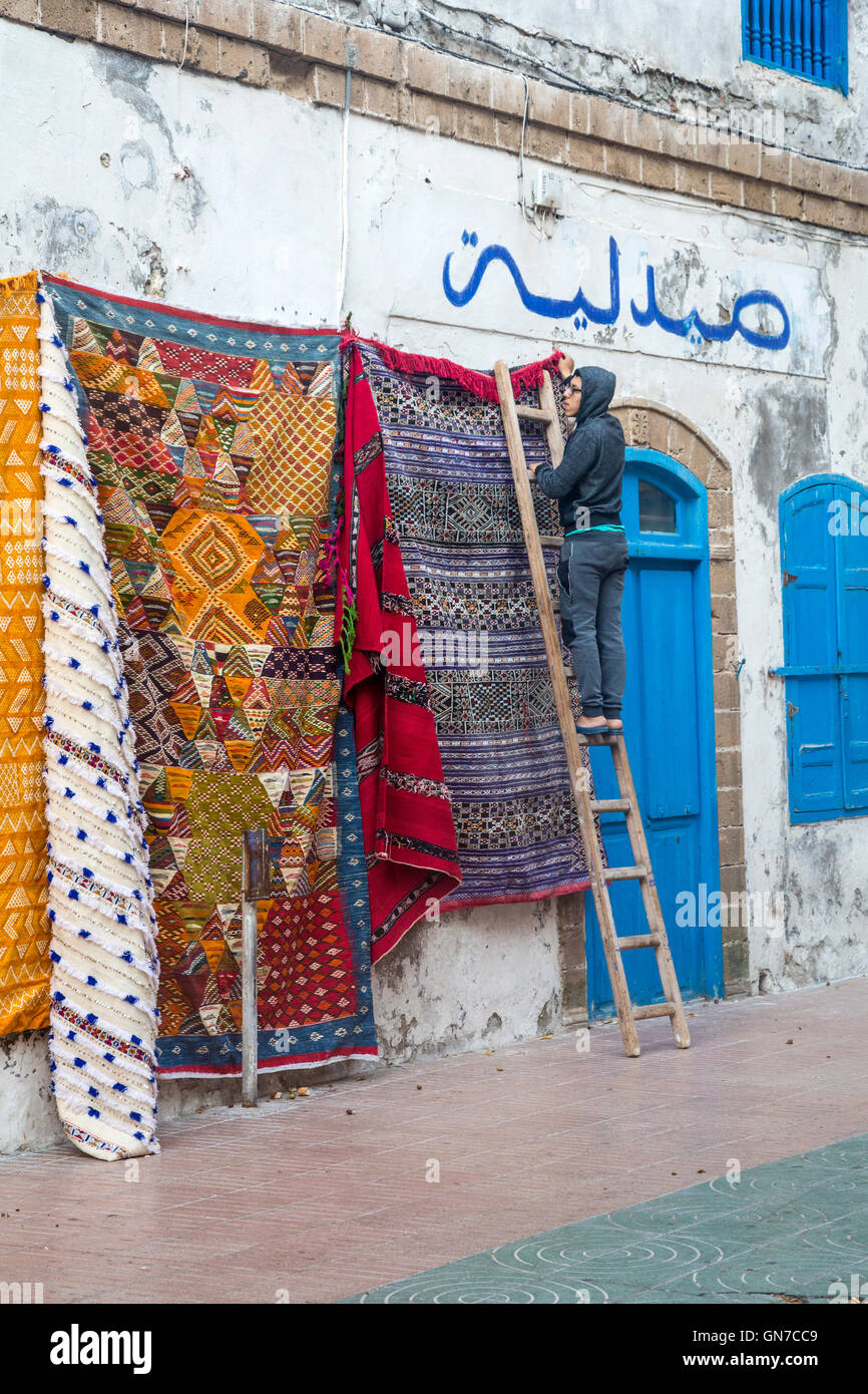 Essaouira, Maroc. Tapis suspendus pour la vente, tôt le matin, lieu Chefchaouini. Banque D'Images