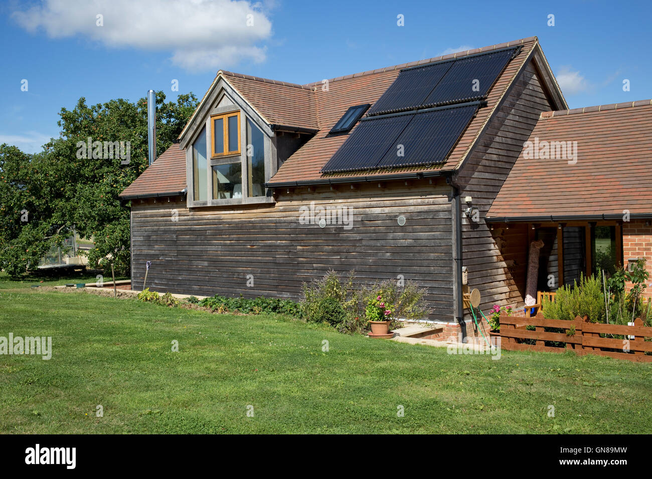 Oak barn vêtu avec chauffage solaire thermique sur le toit, Cotswolds, Royaume-Uni Banque D'Images