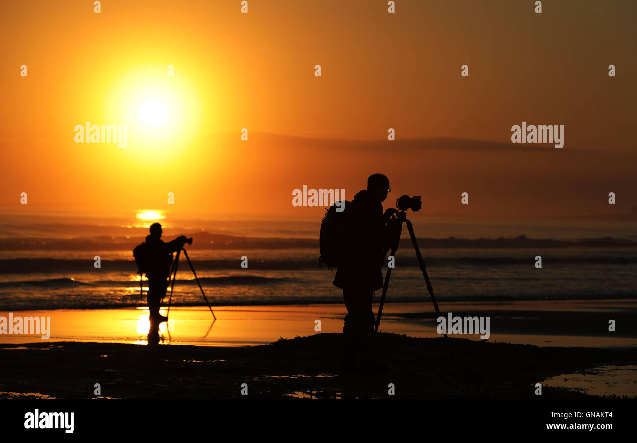 Capture les photographes le soleil se lever sur la plage de Bamburgh Northumberland, comme les Britanniques peuvent s'attendre à un barbecue pour les vacances de temps comme la semaine dernière, le redoux se poursuit. Banque D'Images