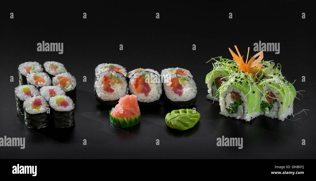 Sushi coloré mélange. Et Uramaki sushi Hosomaki roule sur fond noir Banque D'Images
