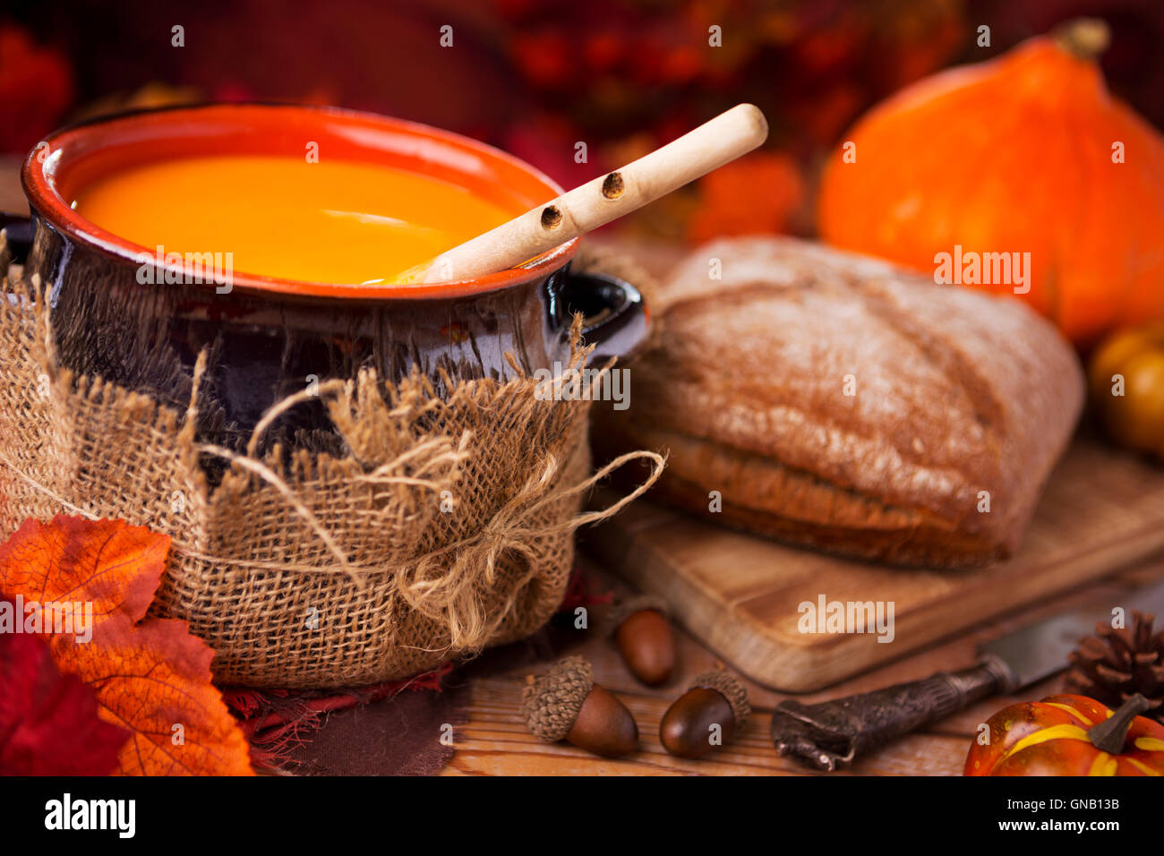 Un pot de crème maison soupe de potiron sur une table rustique avec des décorations d'automne. Banque D'Images