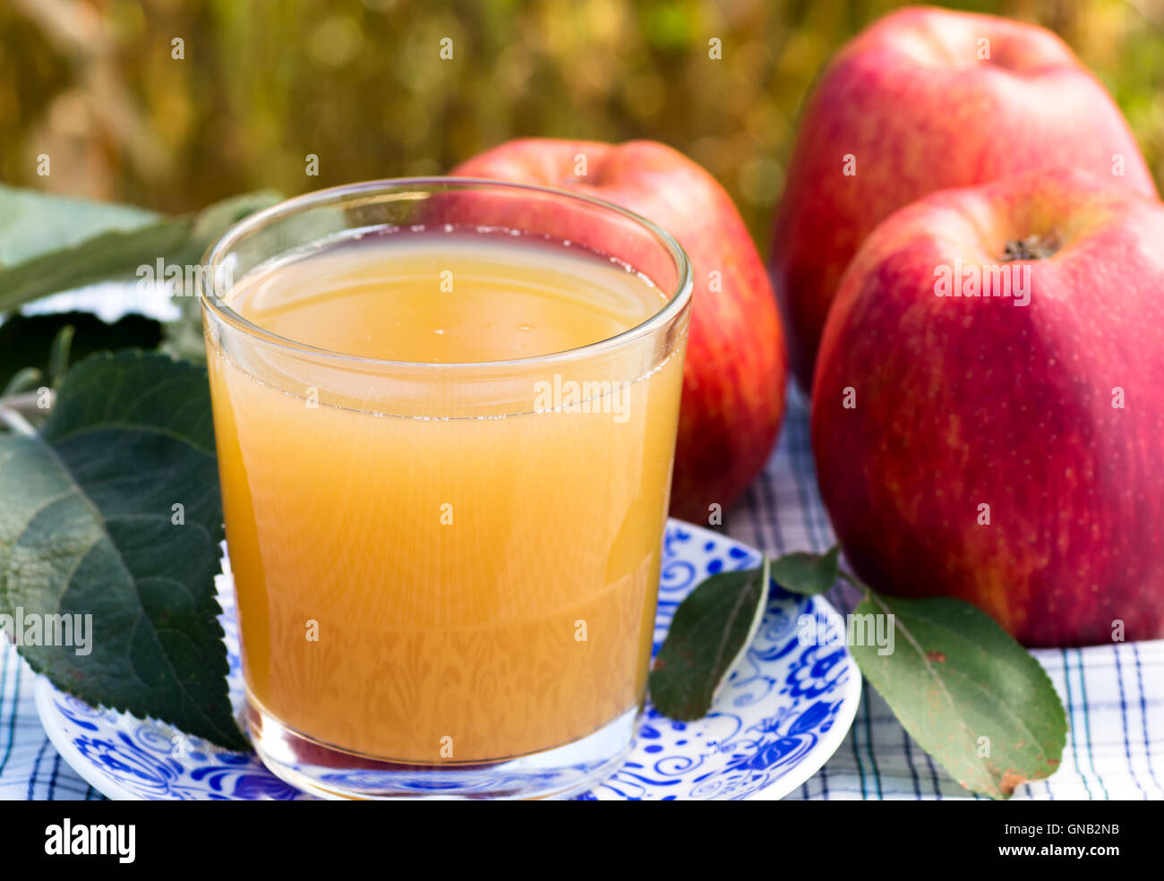 Verre de jus de pomme sur la plaque bleue Banque D'Images