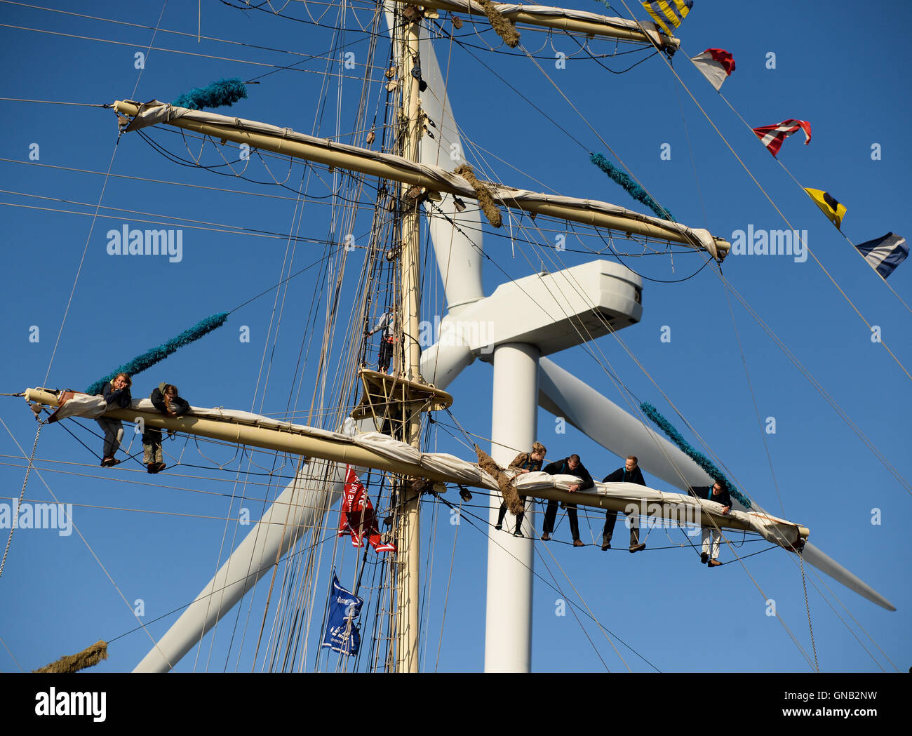 Blyth, Northumberland et de travail de l'équipage en altitude sur le brick polonais 'Chopin' contre un 128 mètres de haut, une éolienne. Banque D'Images