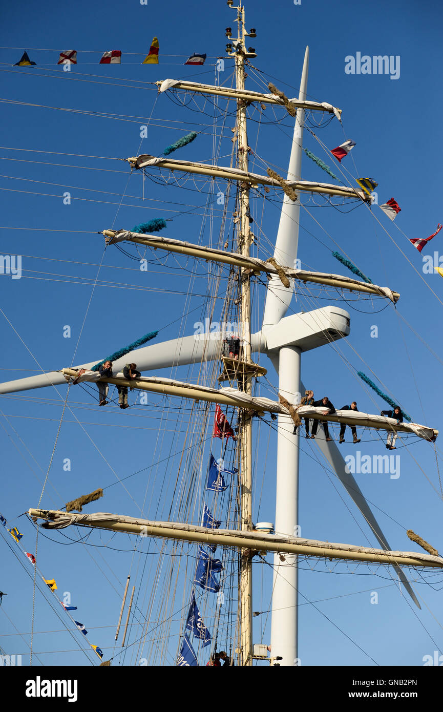 Blyth, Northumberland et de travail de l'équipage en altitude sur le brick polonais 'Chopin' contre un 128 mètres de haut, une éolienne. Banque D'Images