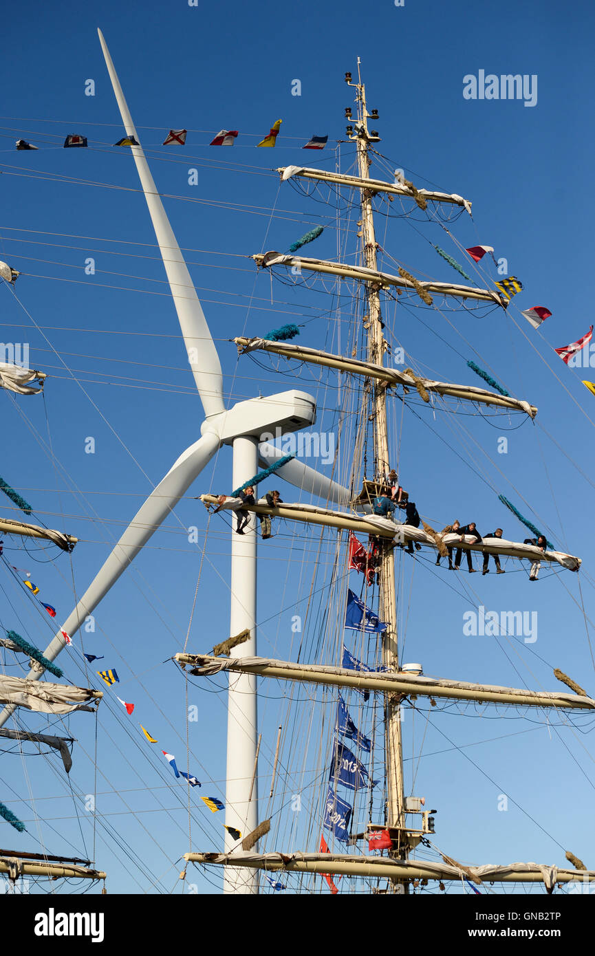Blyth, Northumberland et de travail de l'équipage en altitude sur le brick polonais 'Chopin' contre un 128 mètres de haut, une éolienne. Banque D'Images