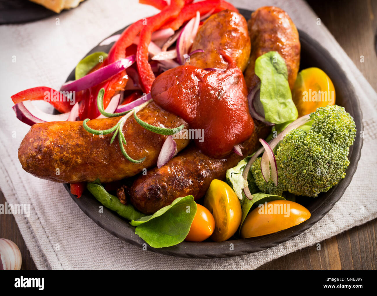 Saucisses faites maison avec des légumes et de ketchup Banque D'Images