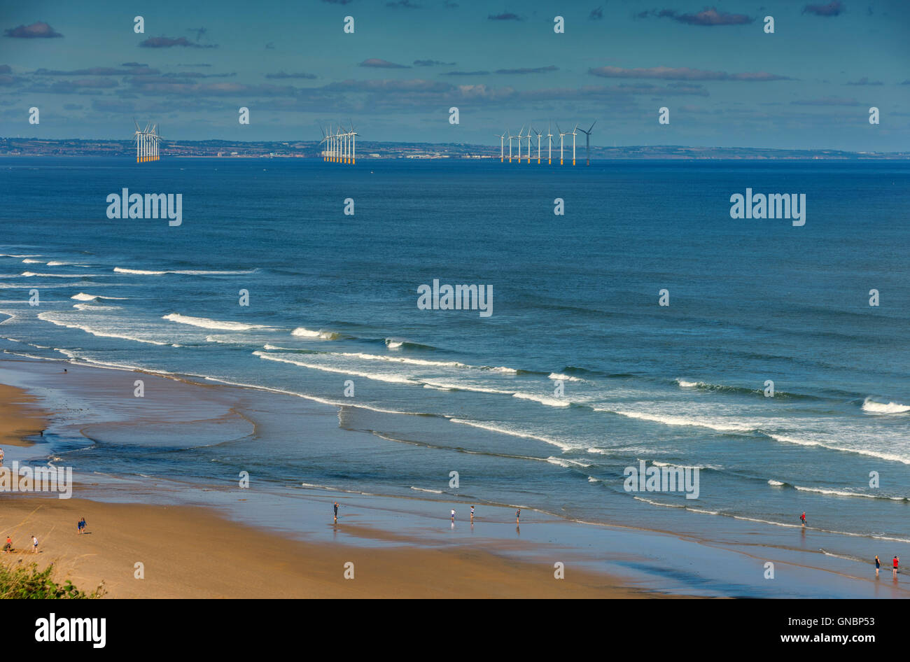 Plage de sable fin, les vagues de surf et vent lointain de la ferme d'éoliennes, Paris, près de la mer Banque D'Images