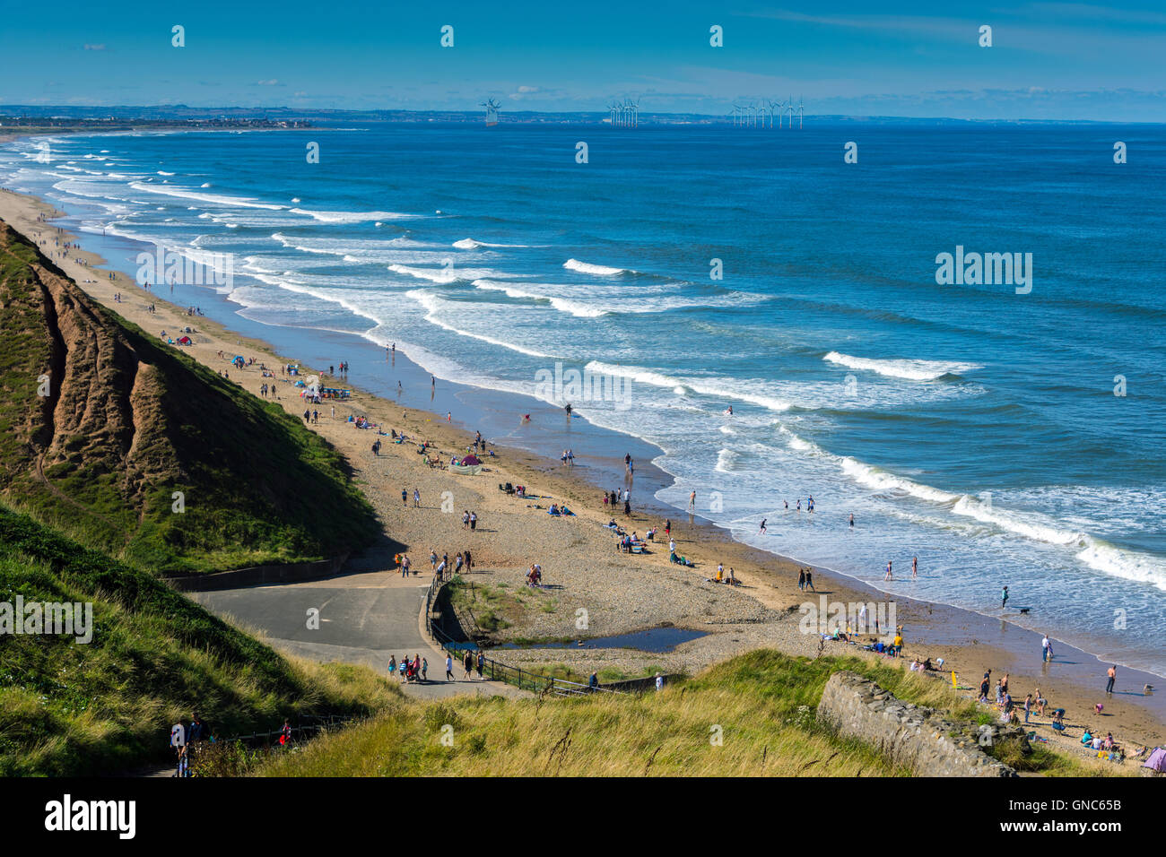 Plage de sable fin, les vagues de surf et vent lointain de la ferme d'éoliennes, Paris, près de la mer Banque D'Images