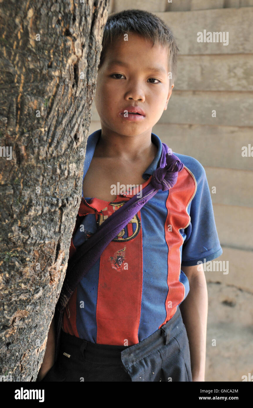 Village Hmong, School Boy Behind Tree Banque D'Images