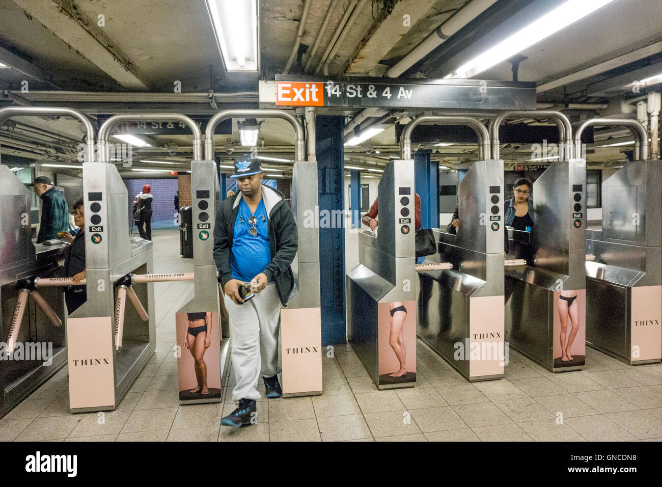 Passagers par tourniquets plâtré avec des publicités pour les sous-vêtements présentés sur les organismes de soutien pour entrer dans la station de métro Union Square Banque D'Images
