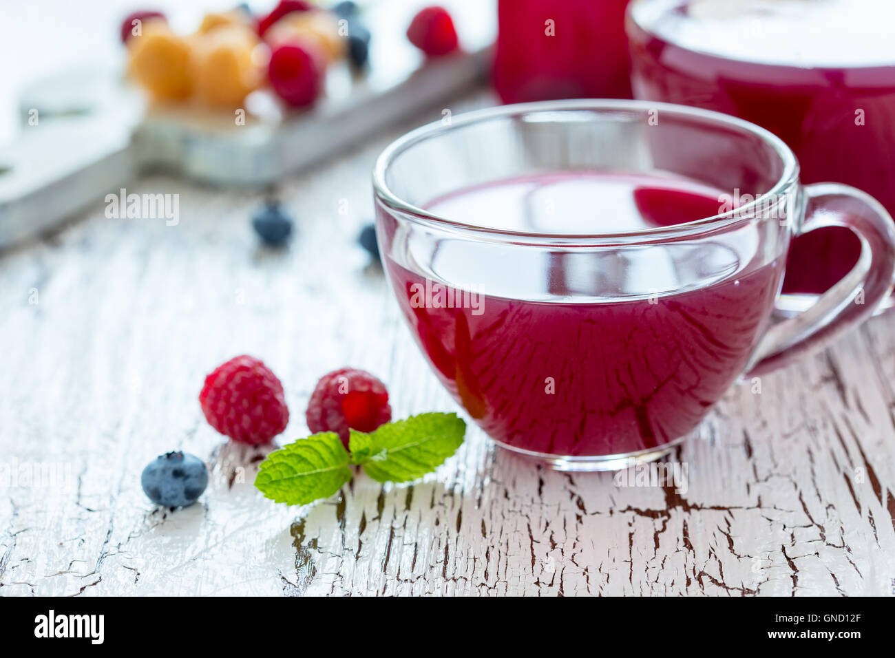 L'été maison rasbarry avec plateau de fruits, de bleuet et de menthe sur la table rustique en bois blanc Banque D'Images
