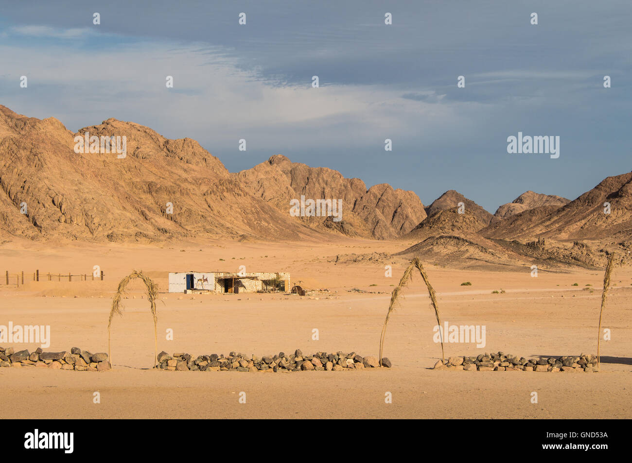 Village bédouin dans le désert en Égypte. Terrain d'avion et de hautes montagnes. Ciel nuageux en début de soirée. Banque D'Images