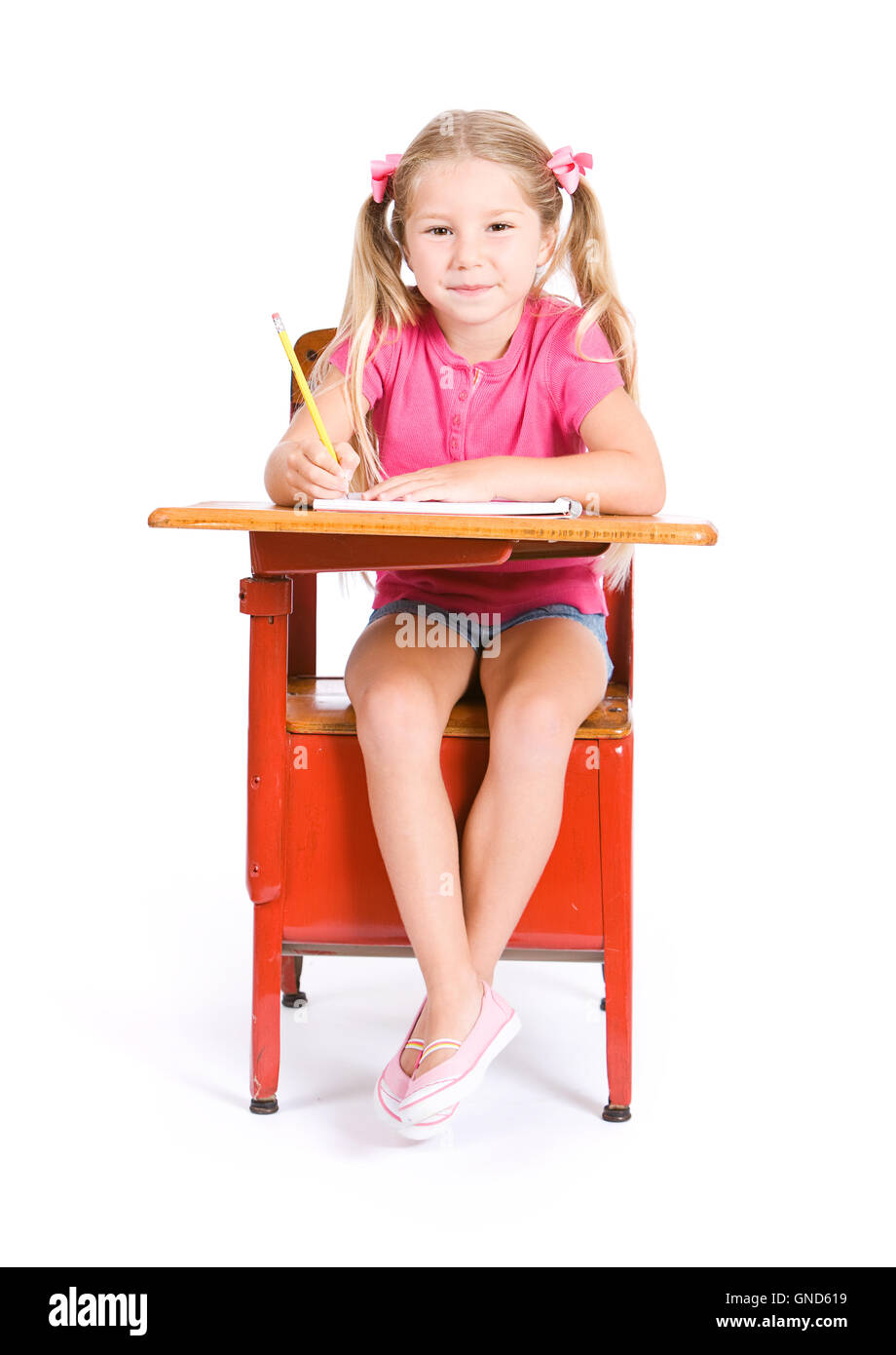 Petite fille étudiant, prêts pour l'école, isolé sur fond blanc. Banque D'Images