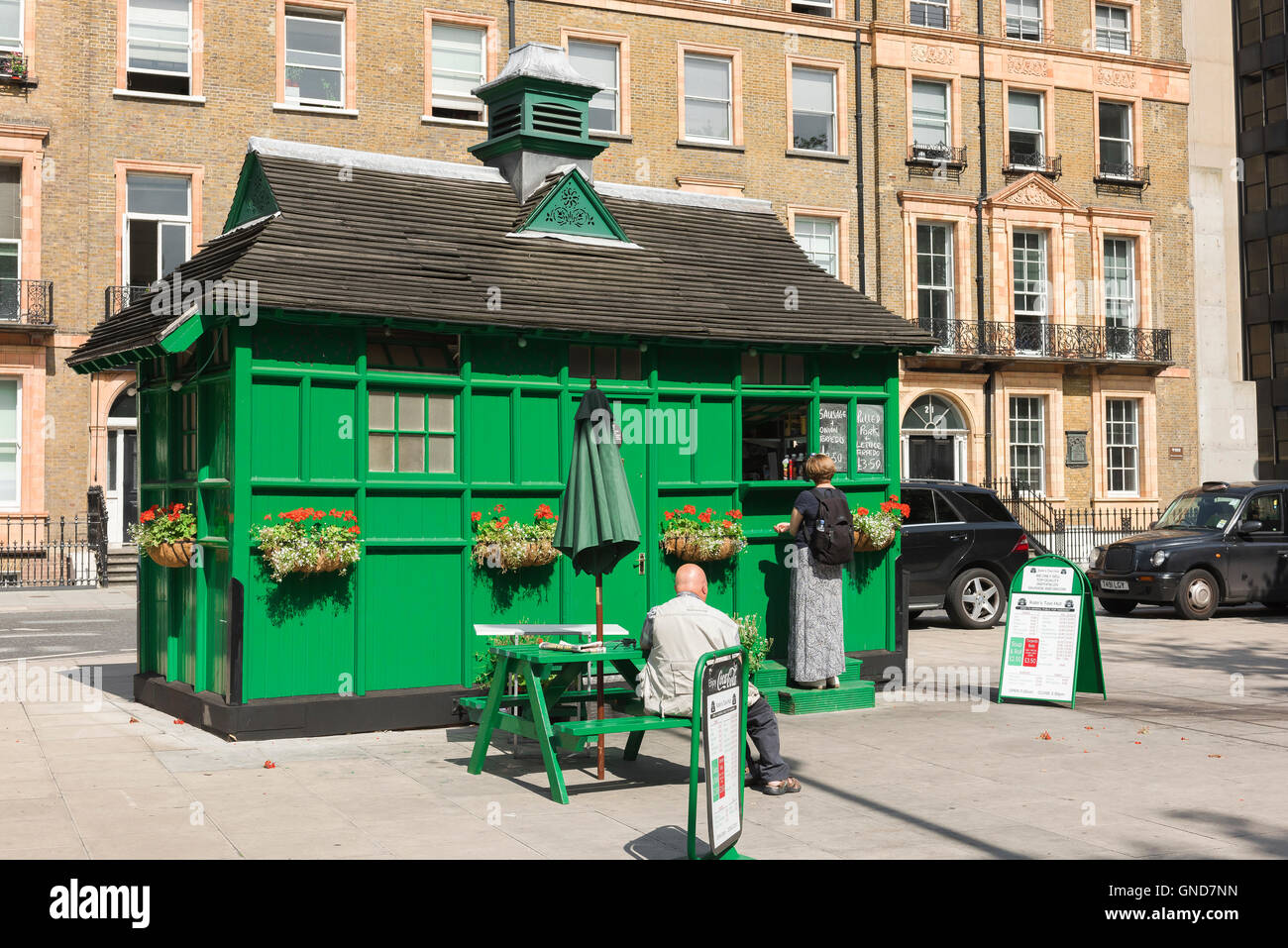 Cabmens d'abris, les gens achètent des aliments provenant d'un dix-neuvième siècle converti en maison d'hébergement pour cocher à Russell Square, Bloomsbury, London, UK. Banque D'Images