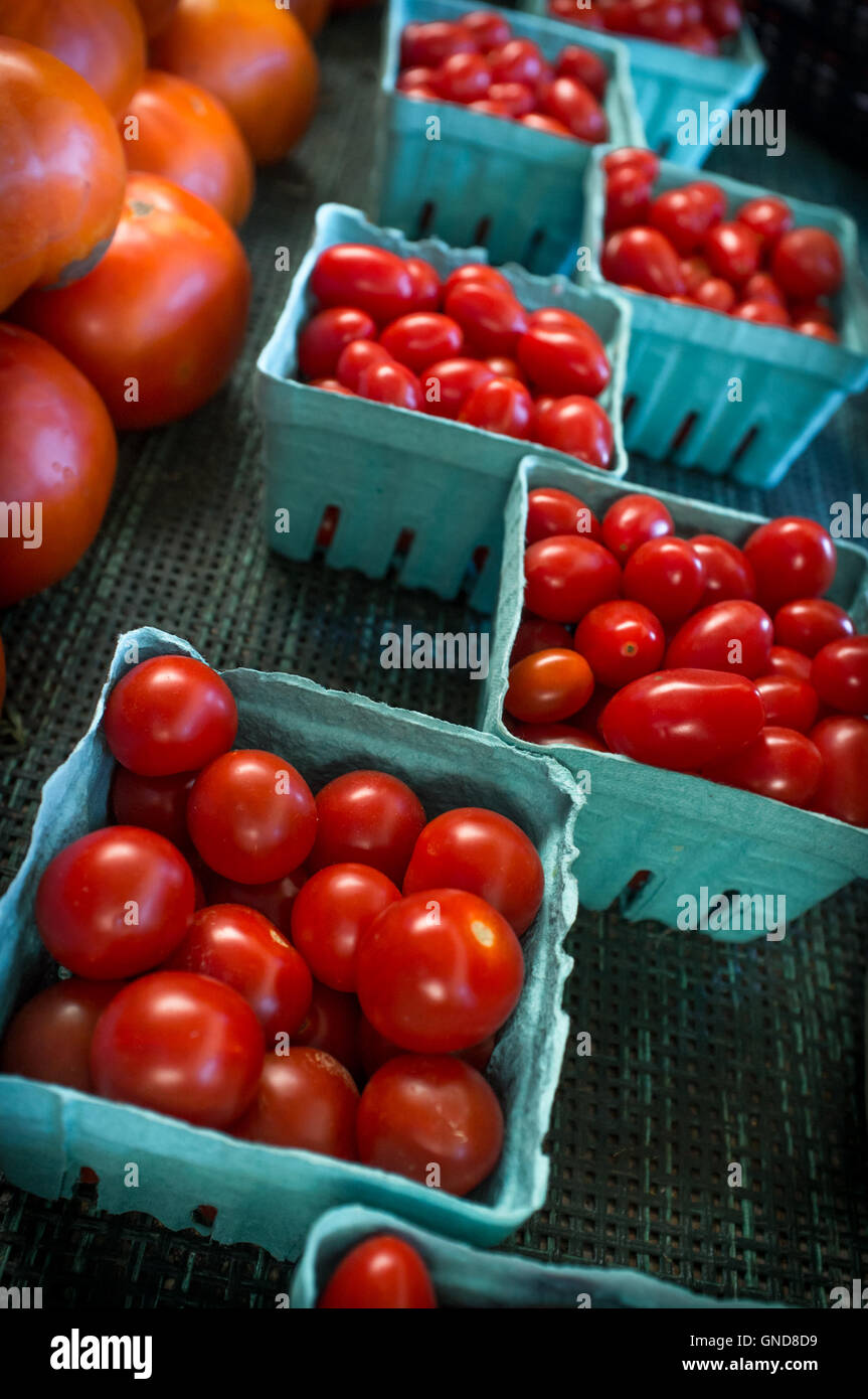 Des paniers de produits biologiques frais tomates raisins rouges au marché agricole local Banque D'Images