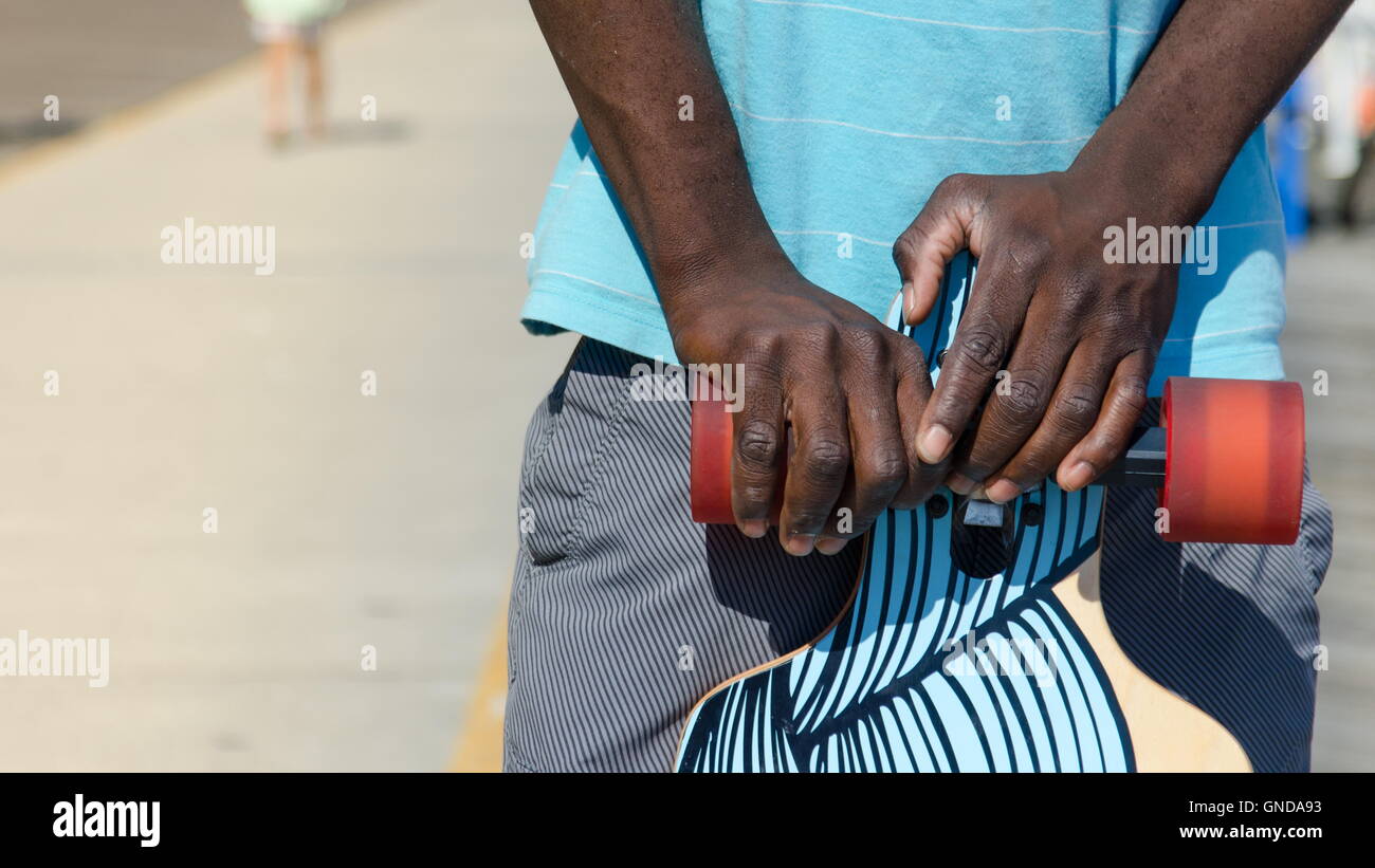 Young African American man holding his skateboard Banque D'Images