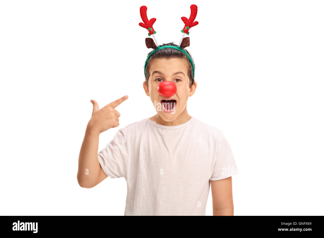 Joyeux garçon posant avec oreilles de renne rouge et un nez rouge et pointant sur eux isolé sur fond blanc Banque D'Images