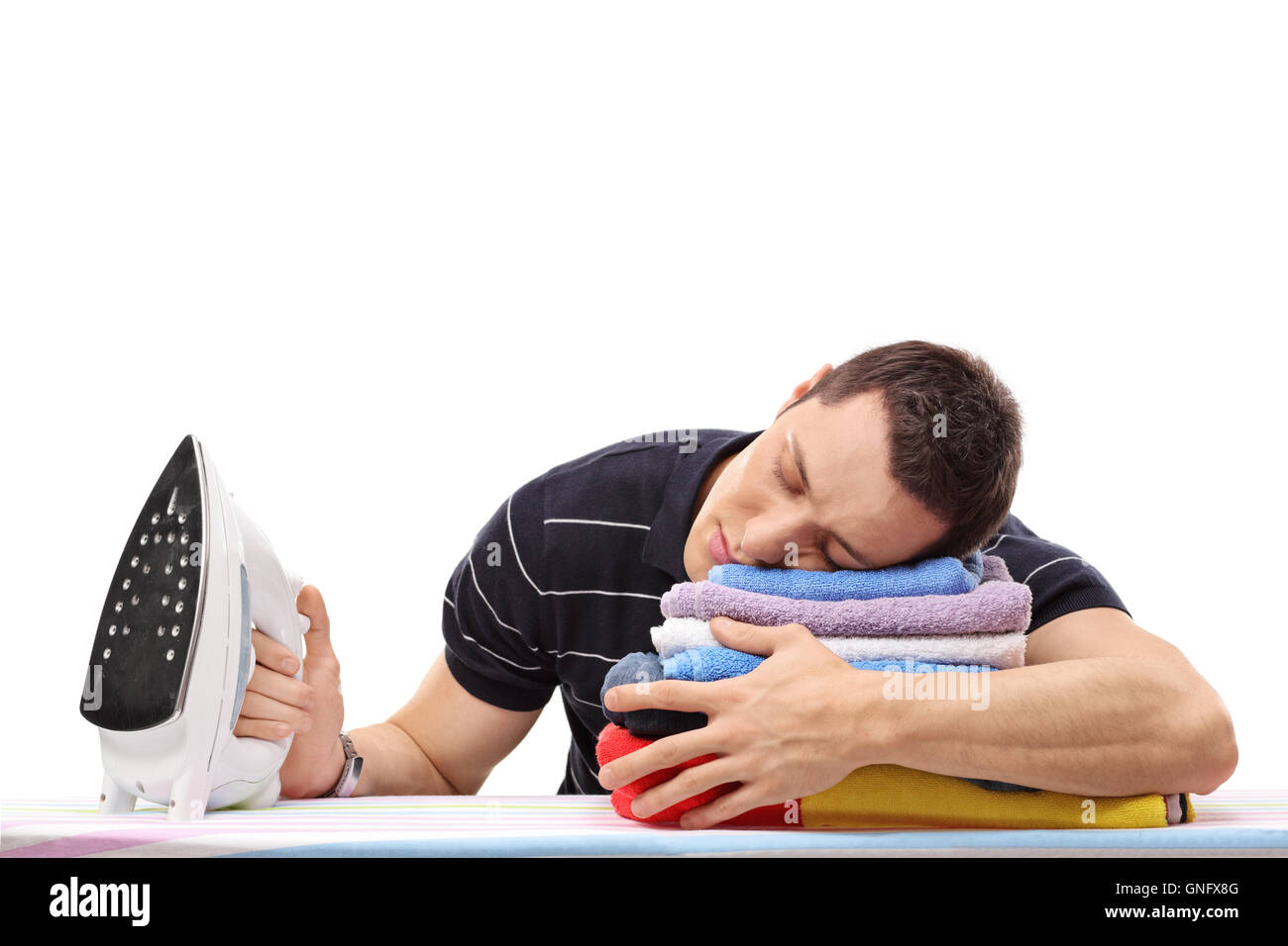 Homme fatigué de dormir sur un tas de vêtements et la tenue d'un fer à repasser isolé sur fond blanc Banque D'Images