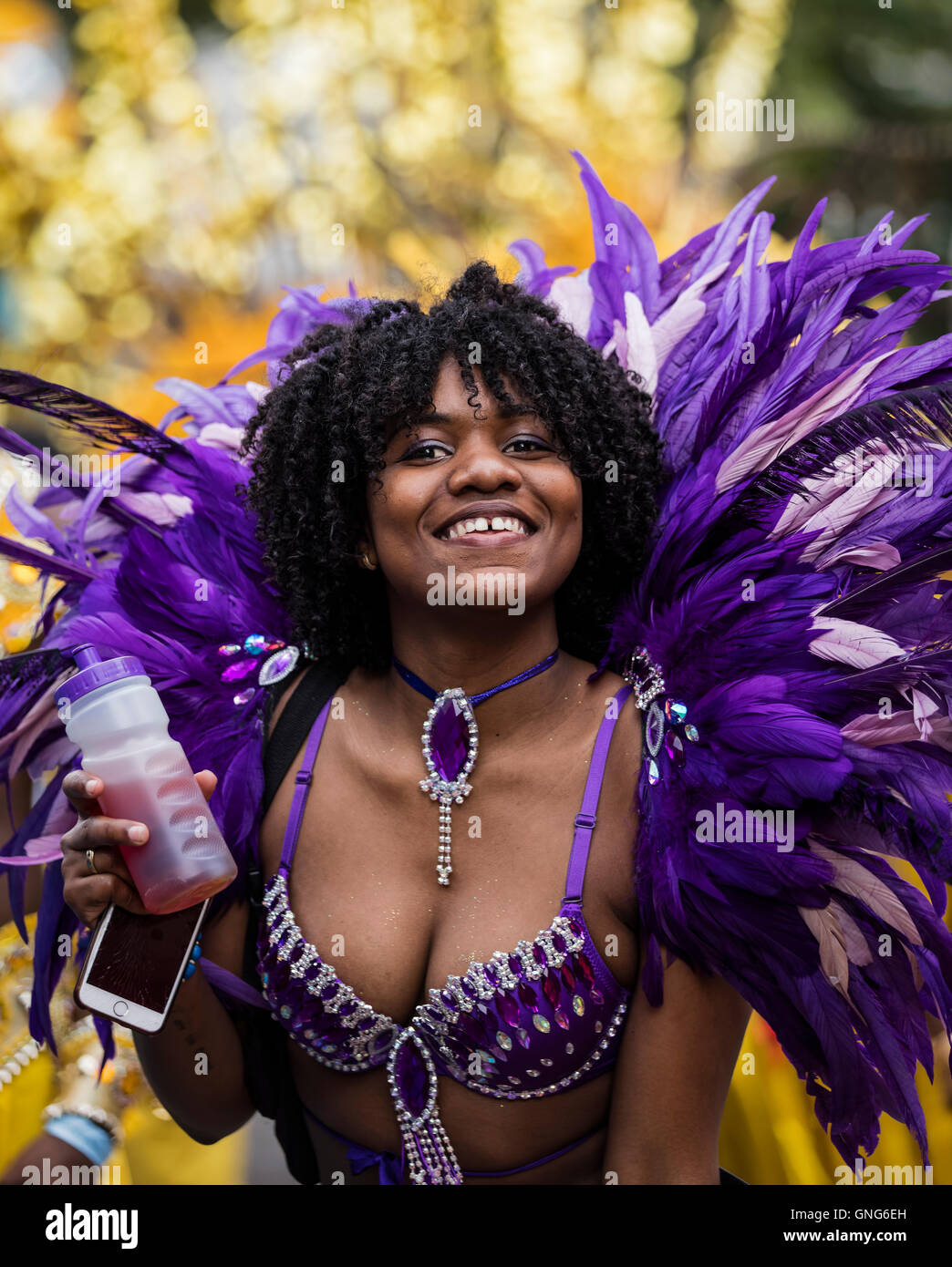 Très belle dame Afro Antillais noir vêtu d'un costume violet avec plumes au carnaval de Notting Hill dans l'ouest de Londres Banque D'Images