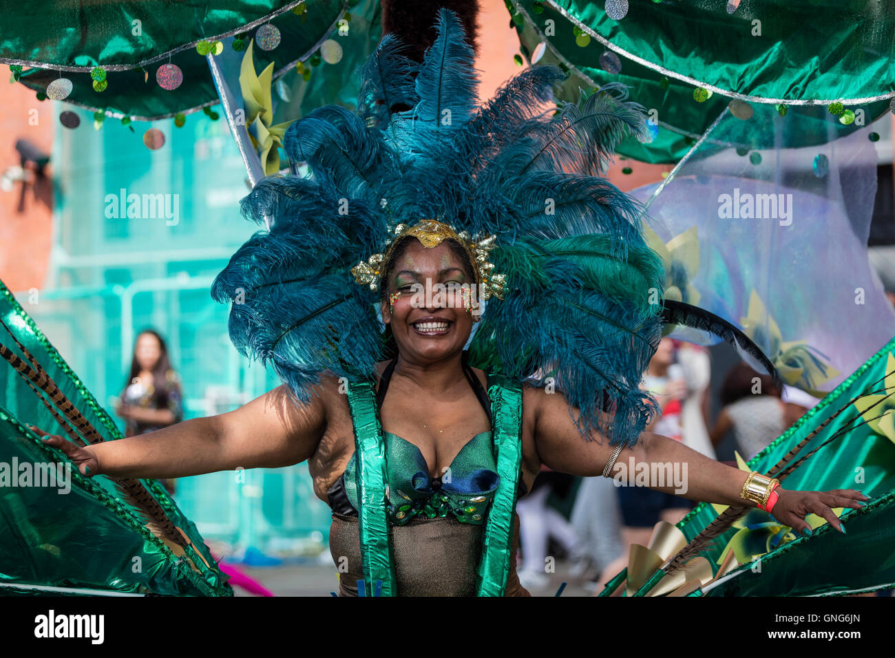Belle femme habillé en costume vert dans le carnaval de Notting Hill dans l'ouest de Londres avec plumes bleu Banque D'Images
